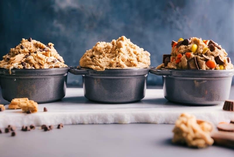 Trio of Edible Cookie Dough Variations: Classic, S'mores, and Peanut Butter Cup Three bowls of edible cookie dough in different flavors: classic chocolate chip, s'mores, and peanut butter cup.