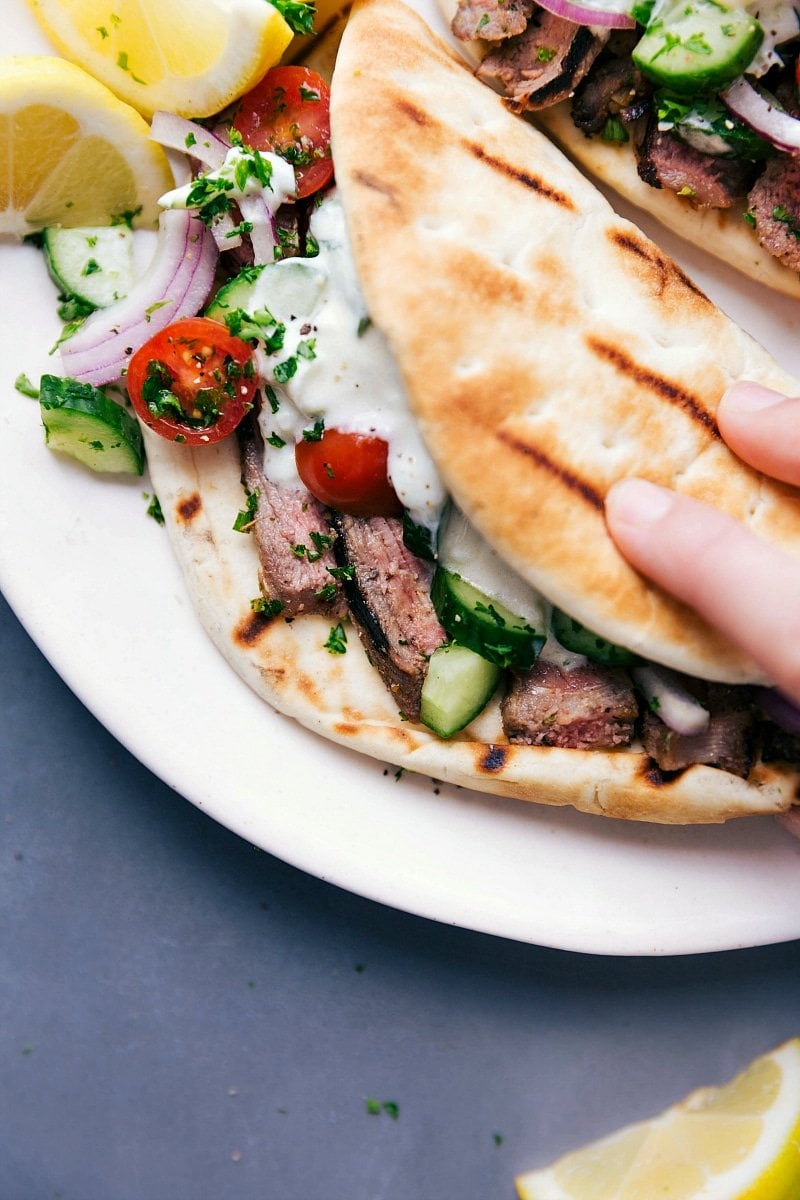 Ready-to-Eat Steak Gyros - Fully Stuffed with Meat, Vegetables, and Sauce Steak gyros fully stuffed with succulent meat, fresh vegetables, and a delicious sauce, ready to be eaten.