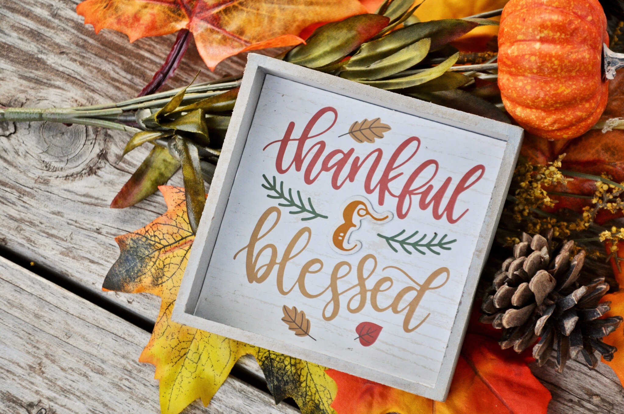 Thanksgiving Foliage and Decor Fall foliage and a plaque that says thankful and blessed.
