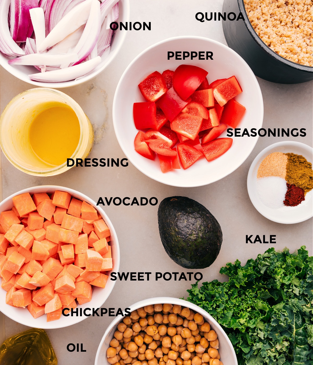 Ingredients In Buddha Bowl All the ingredients in this recipe are prepped, including veggies, seasonings, quinoa, chickpeas, oil, and dressing.