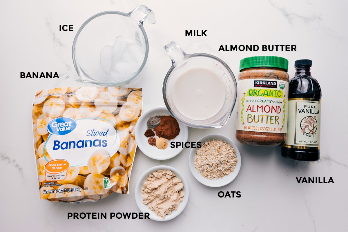 Ingredients In Chai Smoothie All the ingredients in this recipe prepped out for easy assembly including the banana, ice, spices, protein powder, oats, milk, almond butter, and vanilla.