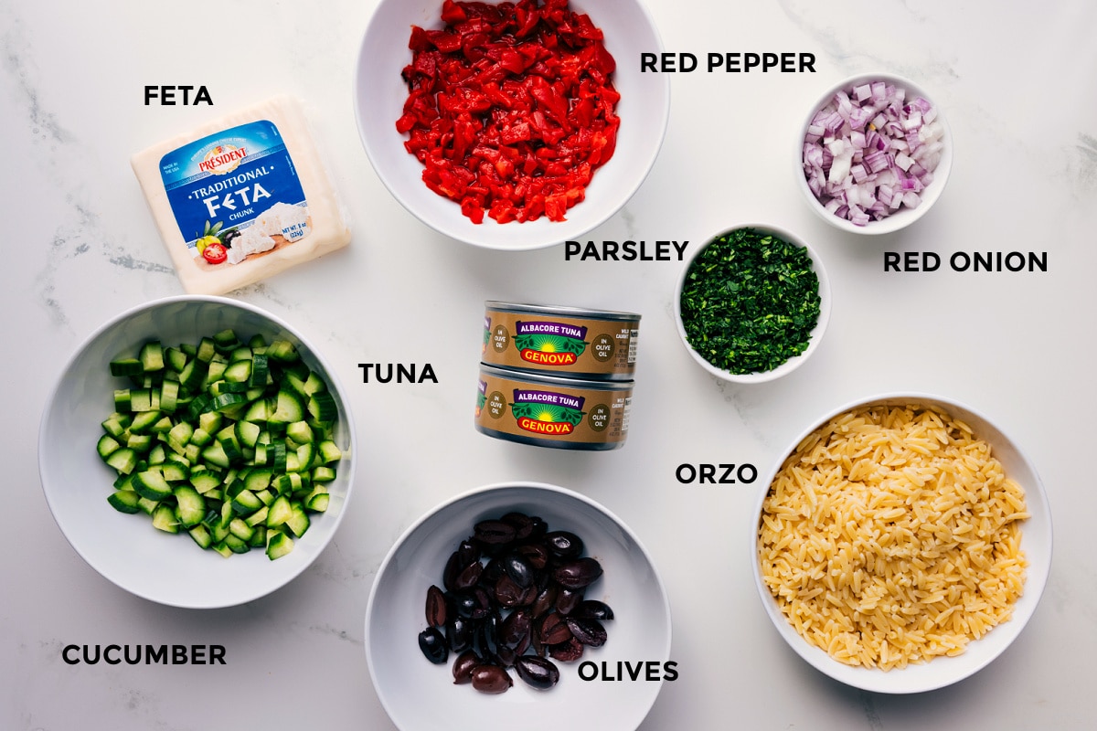 This nutritious and flavorful Mediterranean Tuna Salad has tender orzo pasta, olive-oil-packed tuna, crisp cucumbers, smoky red peppers, tangy red onions, fresh herbs, and a lemon-oregano vinaigrette. This is the best dinner or side salad! Recipe via ChelseasMessyApron.com #tunasalad #tuna #vinaigrette #mediterranean #orzo #healthy #refreshing All the ingredients for Mediterranean Tuna Salad prepped for easy assembly, including feta, red pepper, red onion, parsley, orzo, olives, tuna, and cucumber.