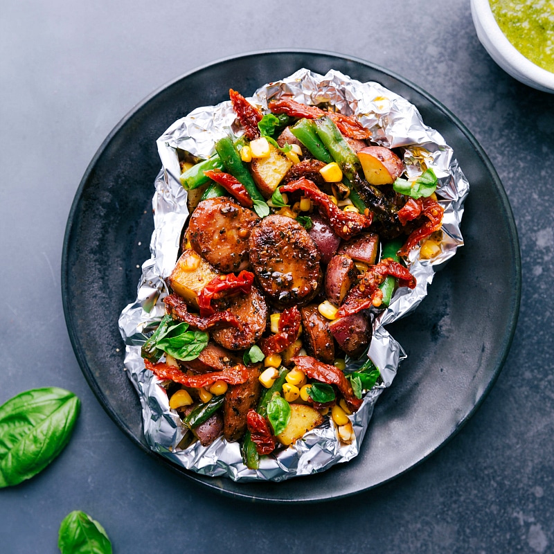 Freshly Grilled Pesto and Sausage, Steaming and Ready to Enjoy Grilled pesto and sausage foil pack just off the grill and ready to serve.