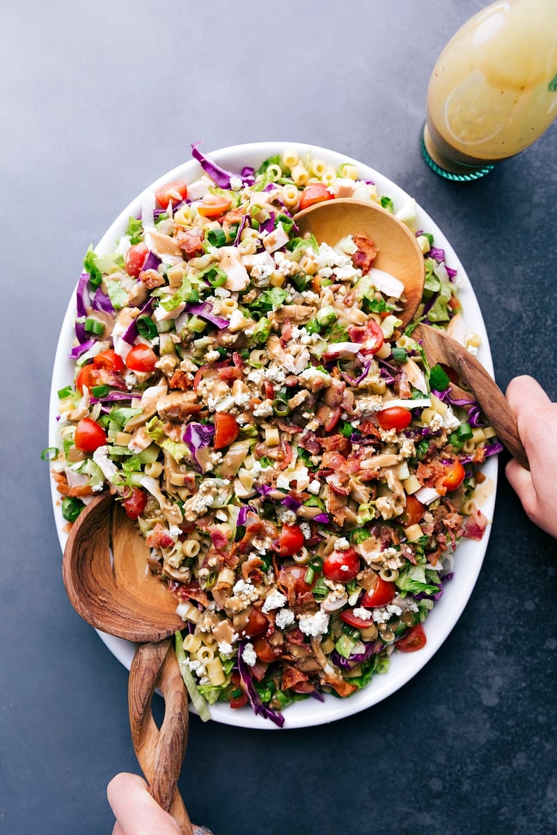 A vibrant bowl of Portillo's Chopped Salad with two serving spoons.