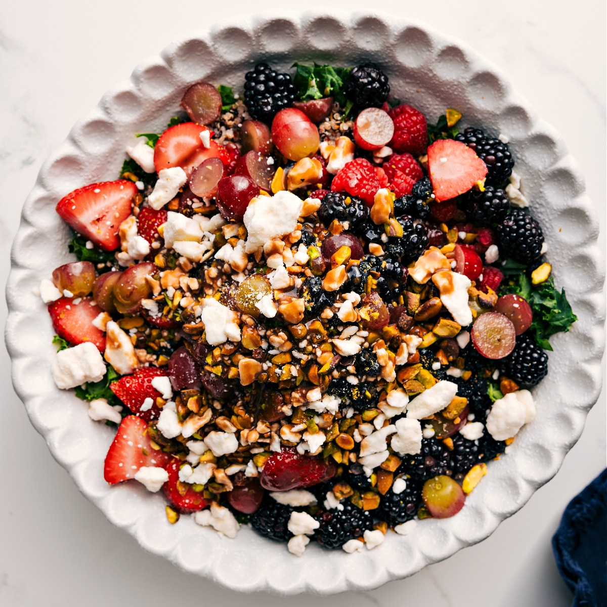 How To Make This Kale And Quinoa Salad The salad with all the ingredients layered in and drizzled over with the dressing.