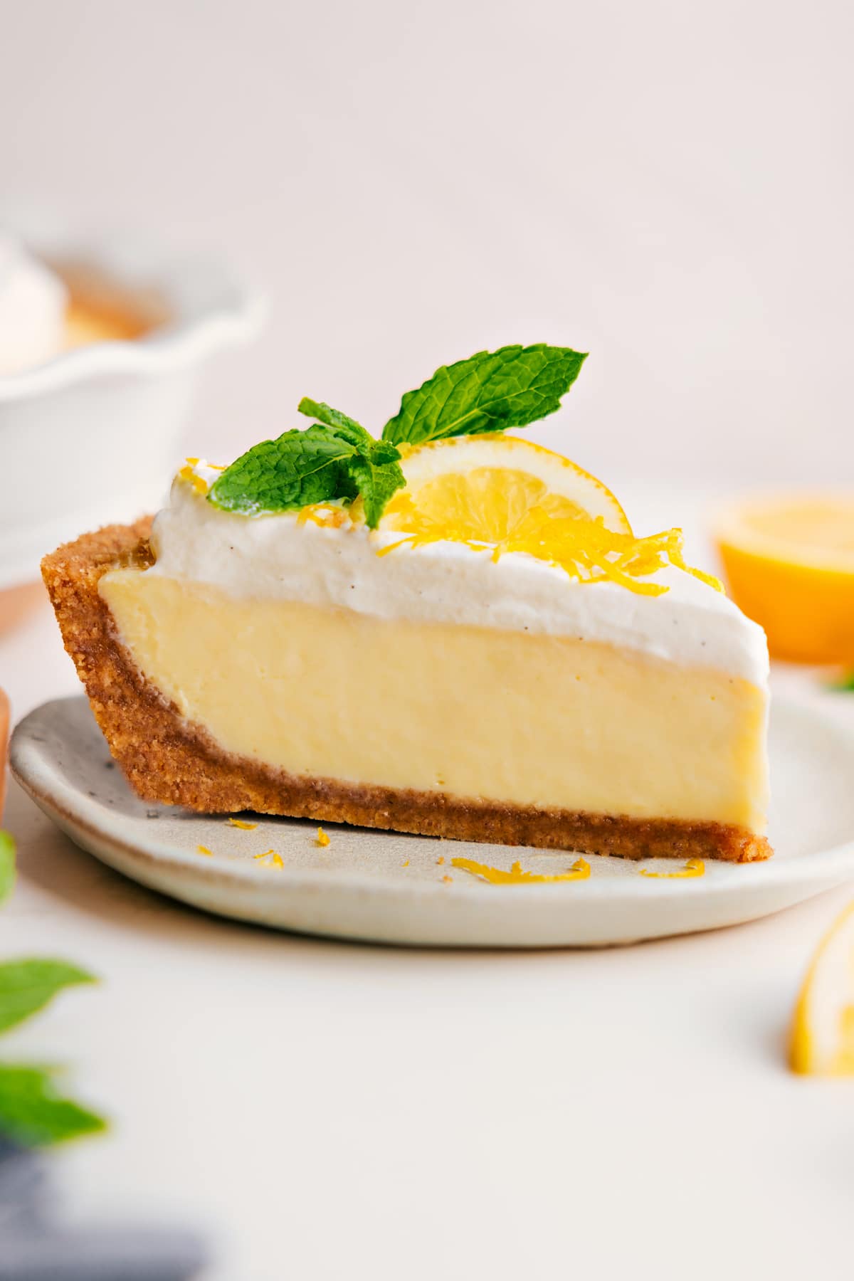 Fresh And Flavorful Lemon Pie Recipe Slice of lemon pie topped with whipped cream, lemon zest, fresh lemon slice, and mint.
