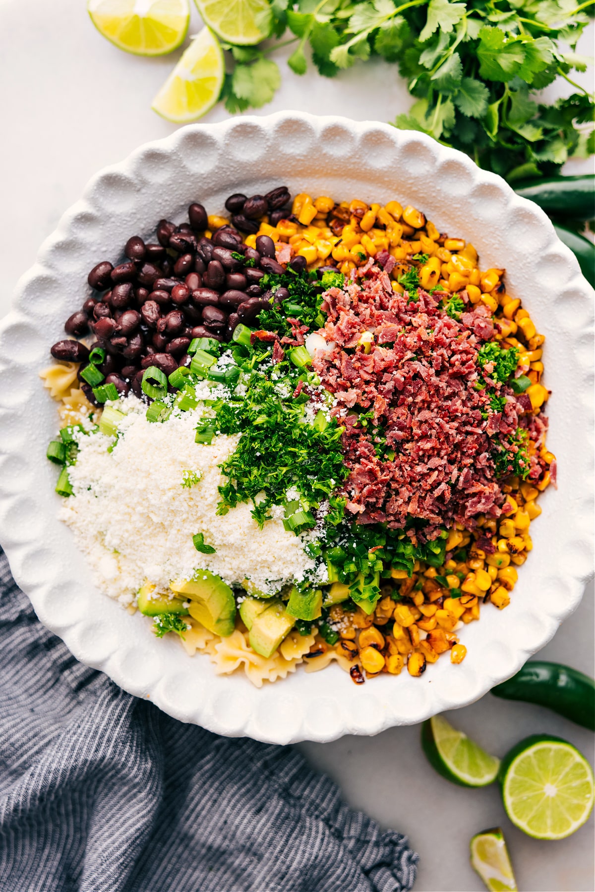 The Best Mexican Street Corn Pasta Salad Recipe Ever All the ingredients for Mexican Street Corn Pasta Salad added to a bowl, ready to be tossed and dressed with the sauce.