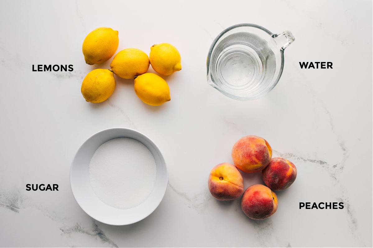 All the ingredients in this recipe prepped out for easy assembly including the lemons, sugar, water, and peaches.