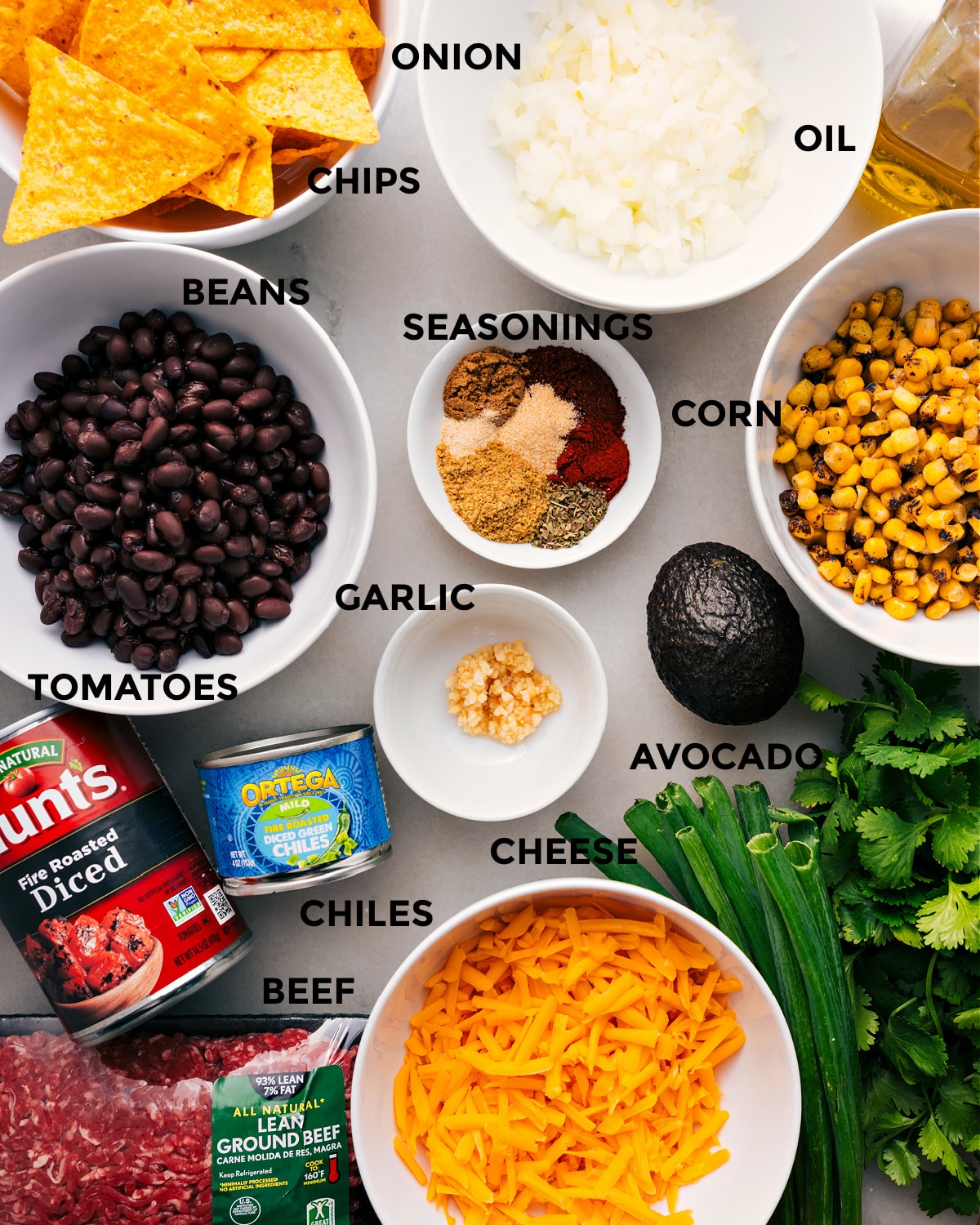 Ingredients In Taco Skillet Recipe Prep all the ingredients for easy assembly, including the seasonings, meat, corn, avocado, garlic, tomatoes, chiles, cheese, chips, and fresh herbs.