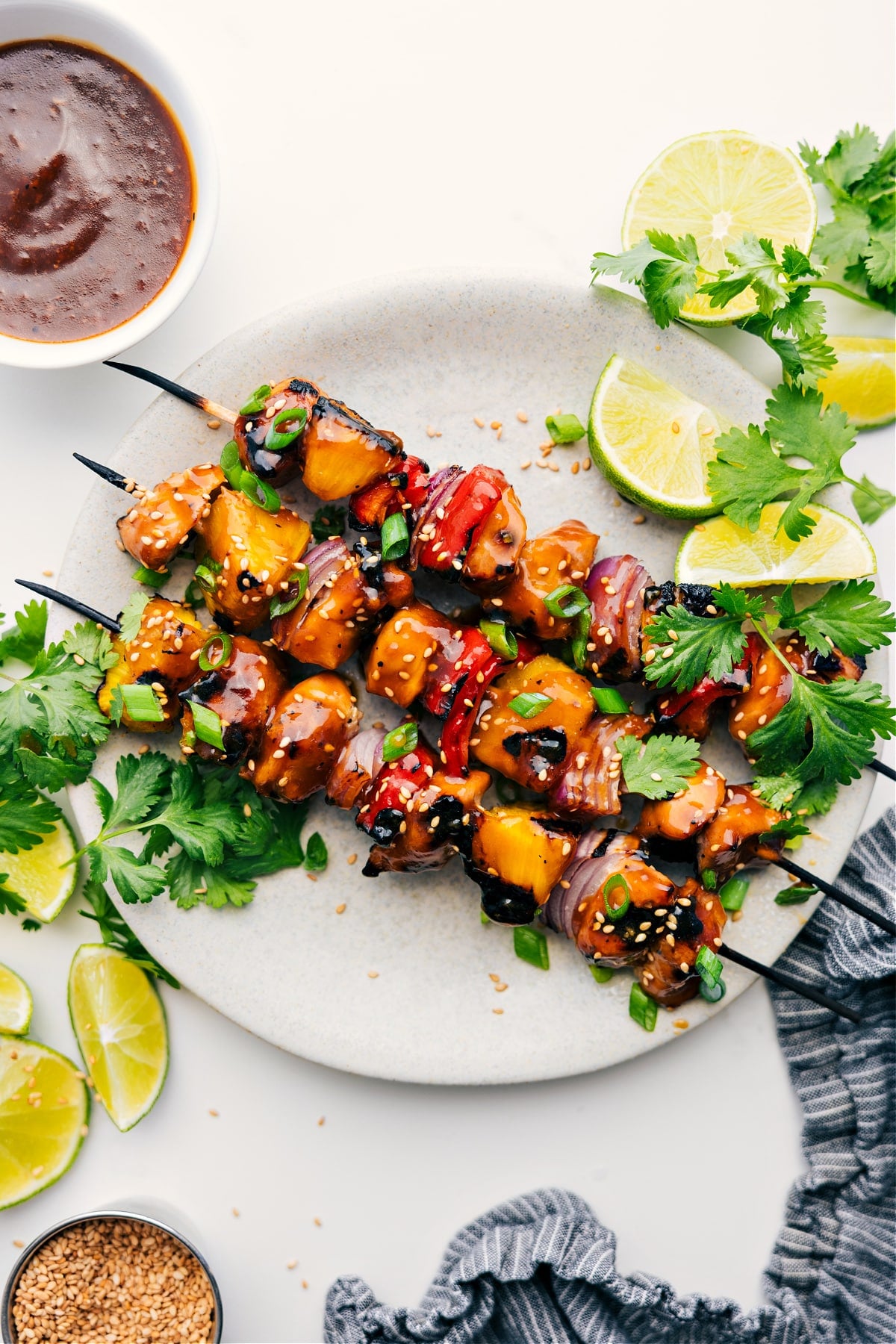 Teriyaki Chicken Skewers Are The Best Summer Dinner Teriyaki Chicken Skewers served with lime wedges, cilantro, and dipping sauce.