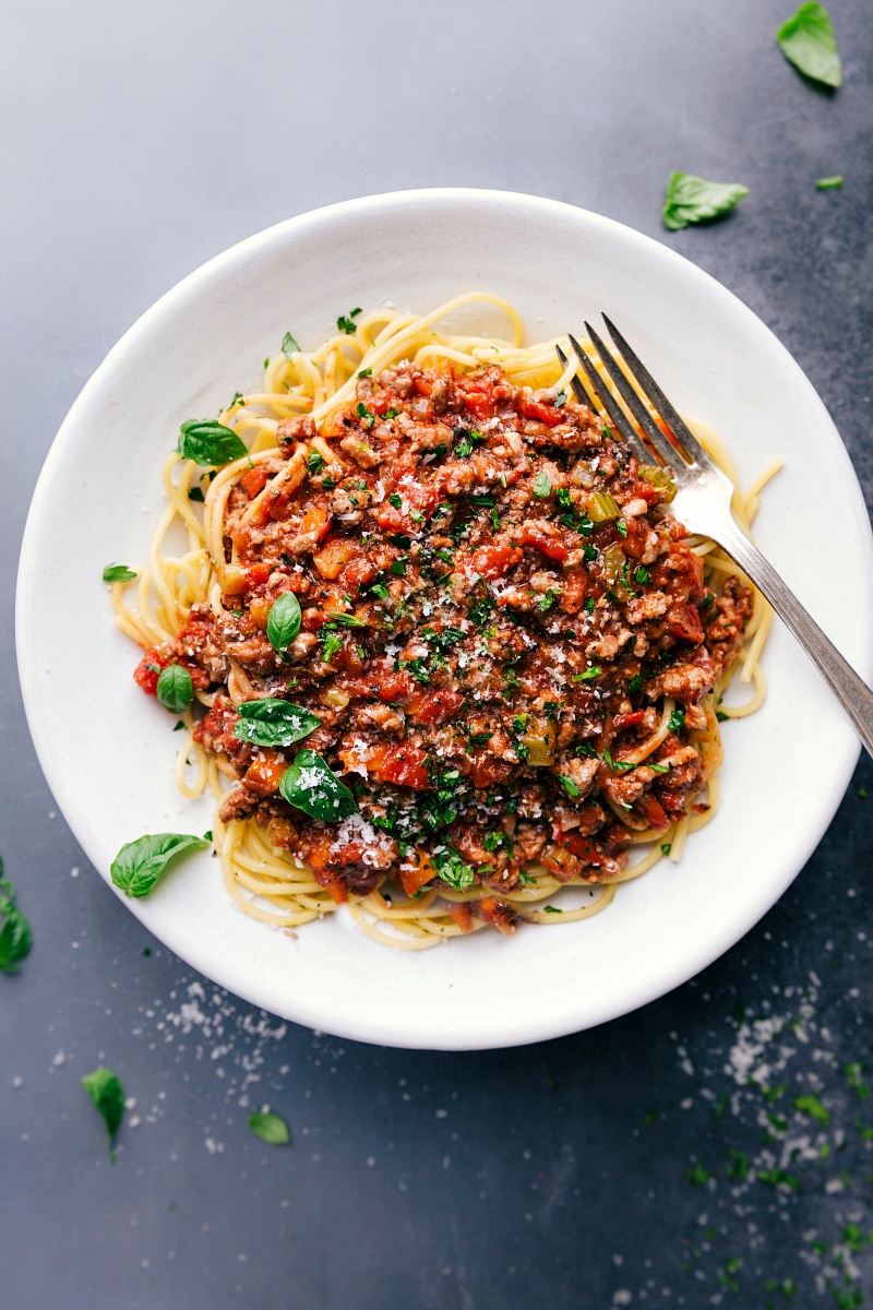 Turkey Bolognese on Spaghetti - Savory Dish with Fresh Herbs Savory and delicious turkey bolognese on a bed of spaghetti, topped with fresh herbs.