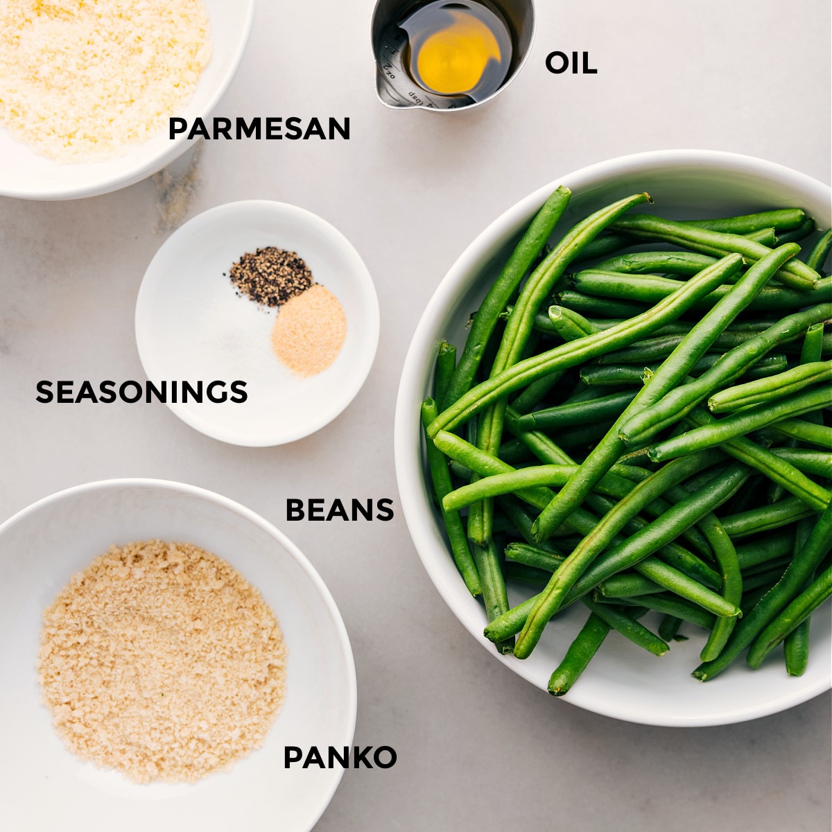 Ingredients In Roasted Green Beans (Two Ways) Ingredients are prepped for easy assembly: beans, panko, seasonings, oil, and parmesan.