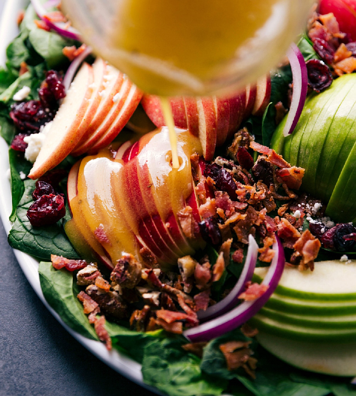 Pouring Homemade Vinaigrette on Spinach Salad Dressing being drizzled over the recipe.