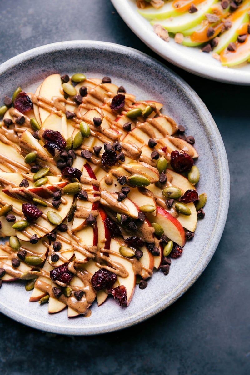 Apple Nachos are the best after-school snack ever! They are just the best! Recipe via ChelseasMessyApron.com #apples #nachos #applenachos #afterschool #snack #fruit Overhead image of the almond butter, peptic, and cranberry version of these treats