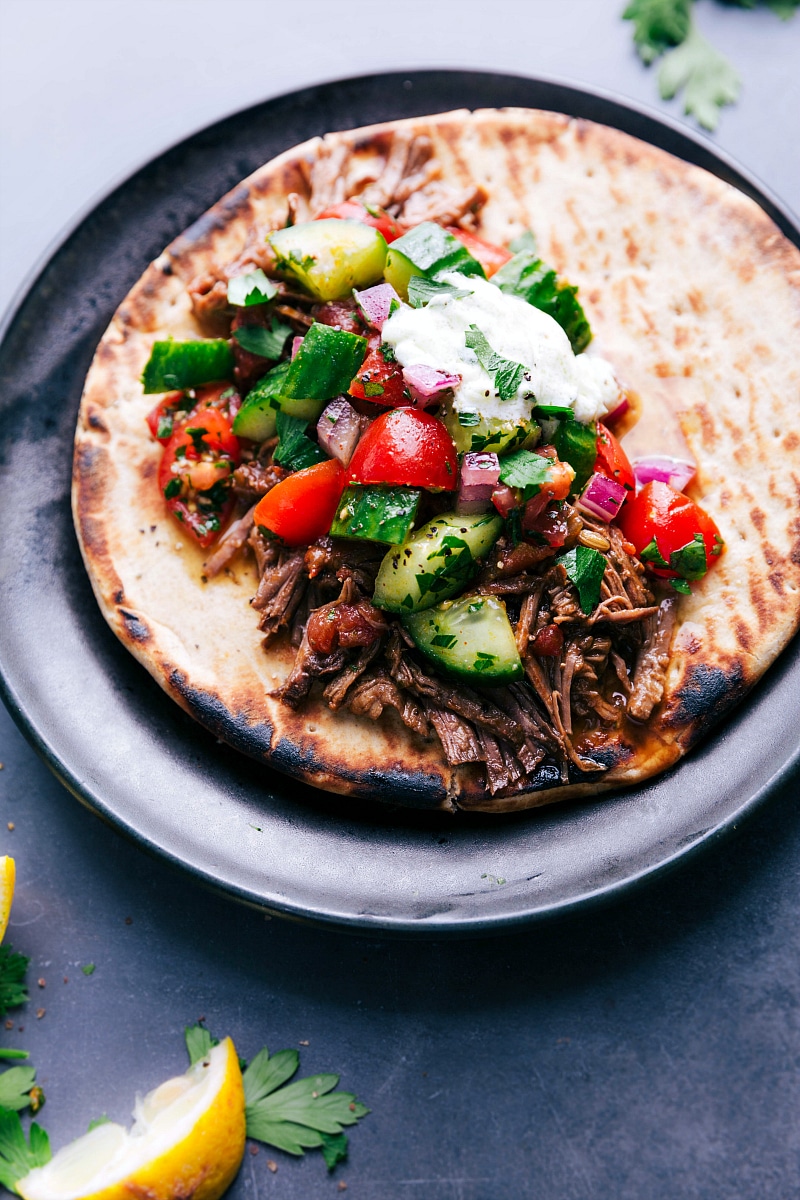 Juicy Beef Gyro on Soft Pita Bread with Fresh Vegetables and Tangy Sauce, Ready to Be Enjoyed Juicy beef gyro on soft pita bread, topped with crisp fresh vegetables and a generous drizzle of tangy sauce, creating a flavorful and satisfying meal.