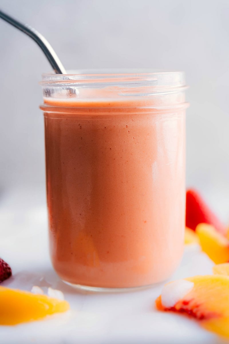 This Peach Smoothie whips together in just a few minutes and only requires five ingredients: frozen peaches, frozen strawberries, frozen mango, frozen banana, and freshly squeezed orange juice. This smoothie is healthy, sweet, creamy, and so flavorful! Recipe via ChelseasMessyApron.com #peach #smoothie #fruity #beverage #breakfast #healthy Peach Smoothie