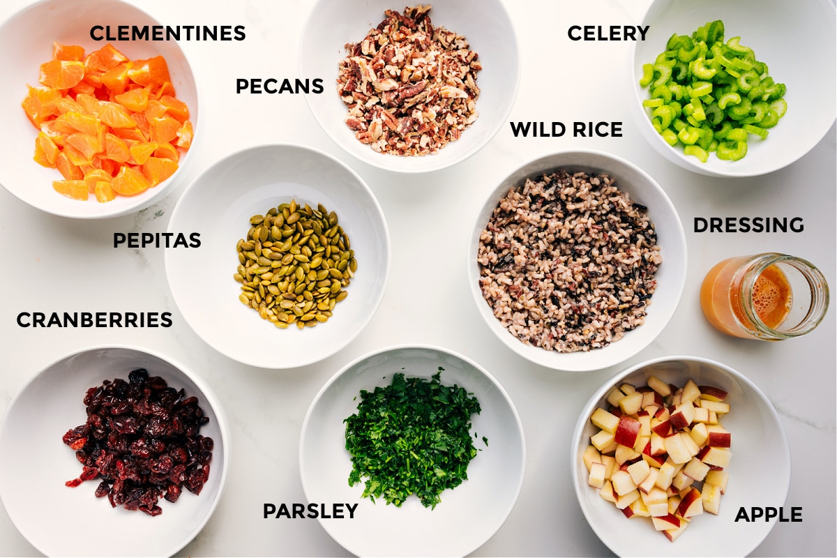 Ingredients In Wild Rice Pilaf Ingredients prepped for this recipe including clementines, pecans, pepitas, dried cranberries, parsley, wild rice, apple, celery, and dressing.