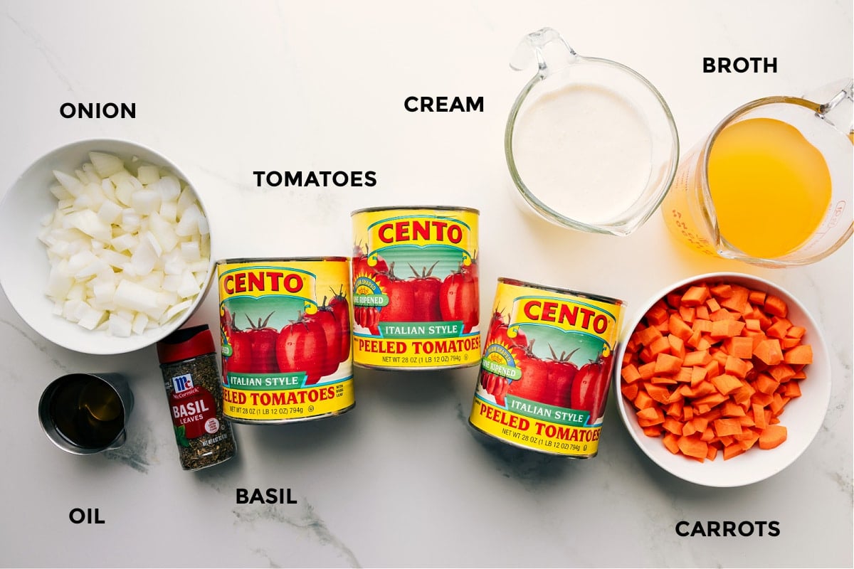 Ingredients In Easy Tomato Soup Recipe All the ingredients in this recipe prepped out for easy assembly including the onion, oil, basil, tomatoes, cream, broth, and carrots.