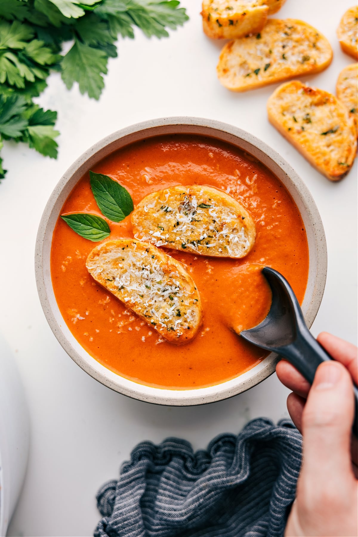 Easy Tomato Soup Recipe Bowl of easy tomato soup topped with a toasted baguette slice.