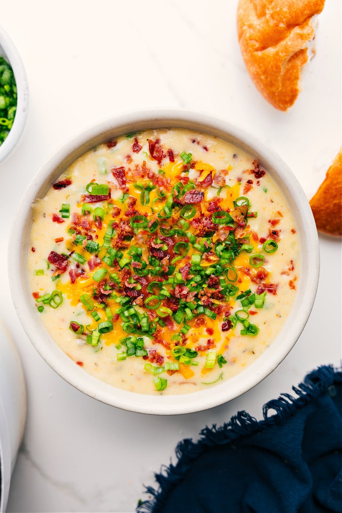 Loaded Potato Soup Recipe served in a bowl, topped with crispy bacon pieces and sliced green onions.