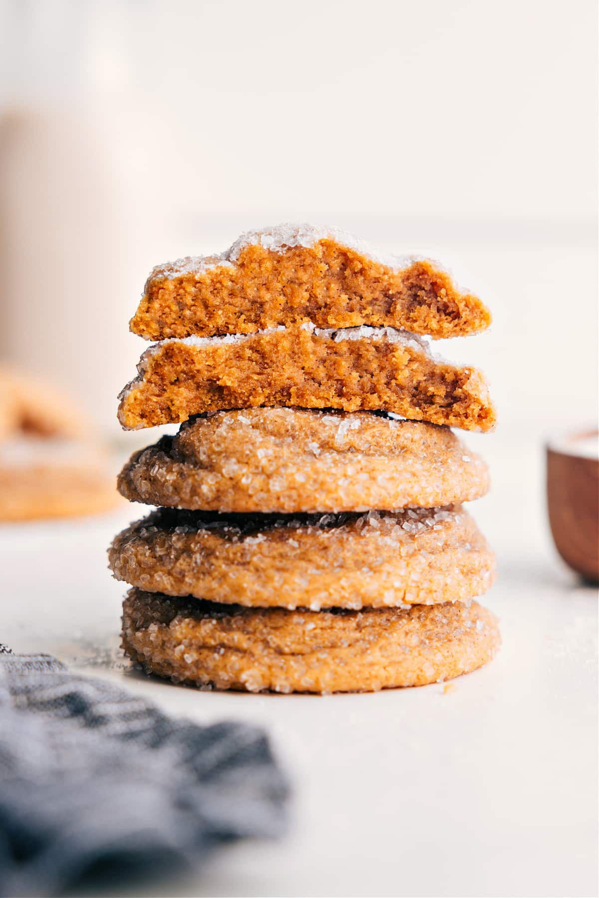 Molasses Cookie Recipe stacked on top of each other with the top one broken in half to show the chewy inside.