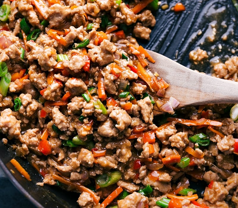 These nutritious bowls are packed with "hidden" veggies and fresh herbs. They're kid friendly and ready in 30 minutes or less! Recipe via ChelseasMessyApron.com #turkeybowl #asian #groundturkey #ricebowl #healthy Close-up view of the Asian Ground Turkey, still in the pan.