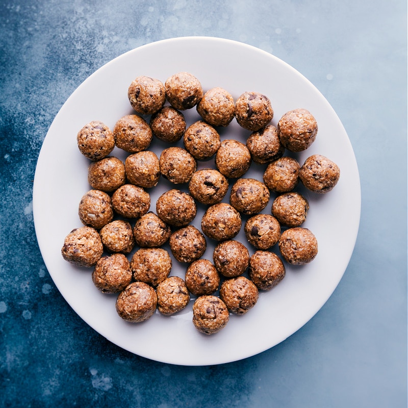 Simple seven-ingredient Oatmeal Energy Balls are filled with oats, coconut, and chunks of chocolate. Recipe via ChelseasMessyApron.com #oatmeal #energyballs #healthy #peanutbutter #honey #coconut View of a plate filled with Oatmeal Energy Balls.