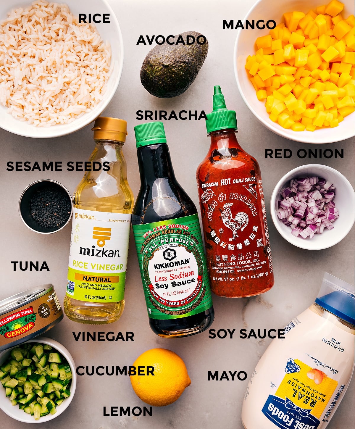 Ingredients In Tuna Stacks All the ingredients are prepped for easy assemblyโmango, onion, soy sauce, sriracha, rice vinegar, rice, avocado, sesame seeds, meat, cucumber, mayo, and lemon.