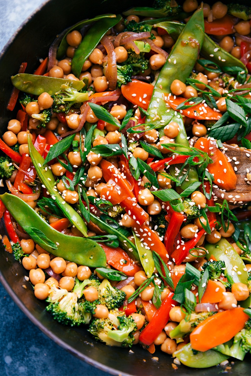 These General Tso Chickpeas make an amazing vegetarian meal with carrots, broccoli, snow peas, a sweet bell pepper, and an array of aromatics. The spicy, tangy sauce that coats these chickpeas and veggies is so quick to whip together and loaded with flavor. Serve these General Tso Chickpeas over rice or cauliflower rice for a low-carb (high-protein) meal. Recipe via chelseasmessyapron #vegan #healthy #clean #veggies #best #quick #easy #simple #broccoli #sesame #generaltso #chickpeas U- close image of General Tso Chickpeas in the pan.