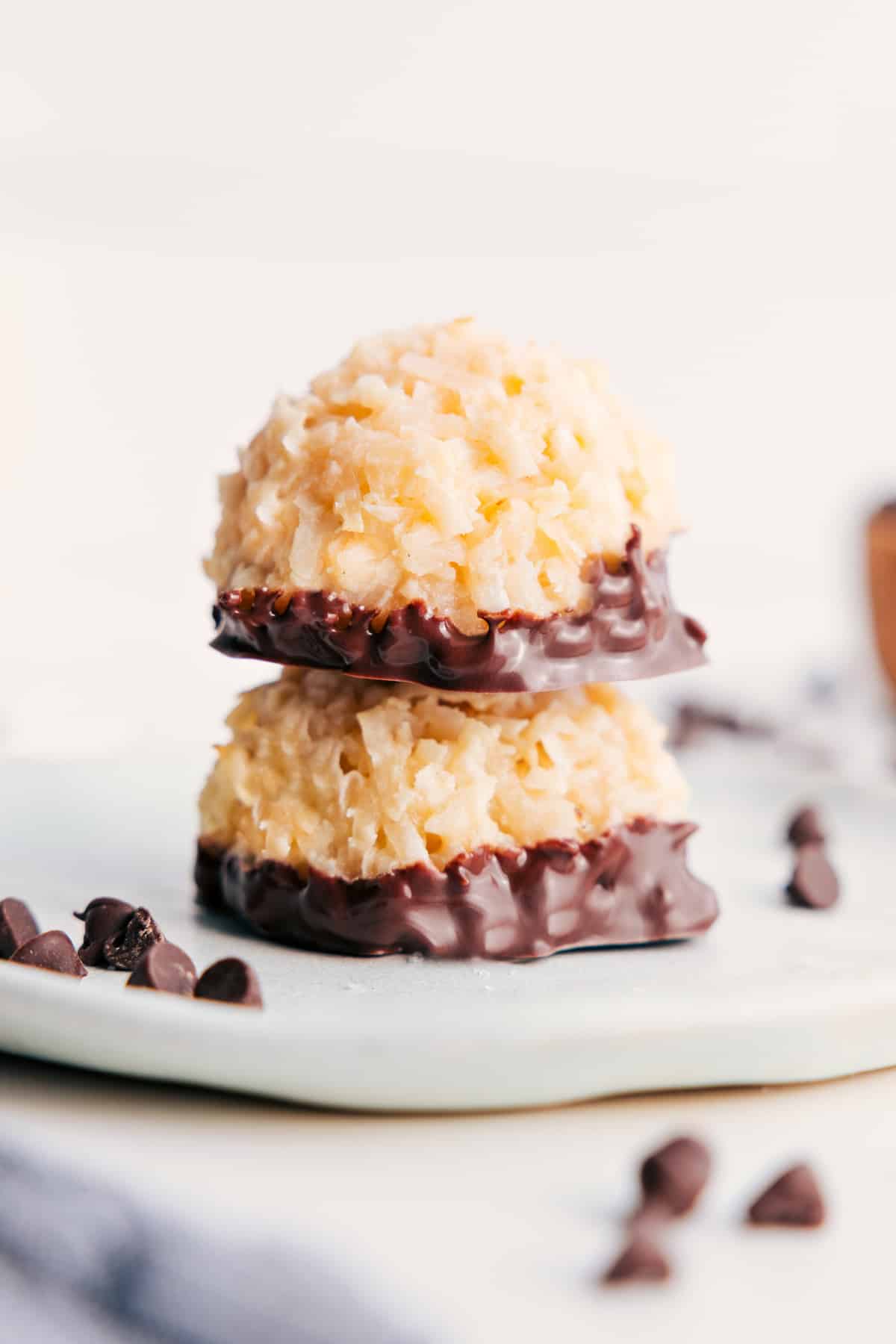 Stack of chocolate dipped coconut macaroons with glossy chocolate coating.