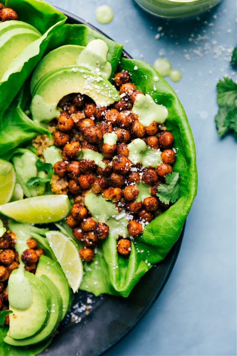 The best-ever Mexican Chickpeas roasted to perfection and drizzled in the best creamy cilantro-lime sauce! Serve these chickpeas in bowls or in lettuce wraps. Recipe via ChelseasMessyApron #dinner #quick #easy #simple #best #healthy #protein #clean #cleaneating #spiced #mexican #chickpeas Mexican Chickpeas in lettuce wraps