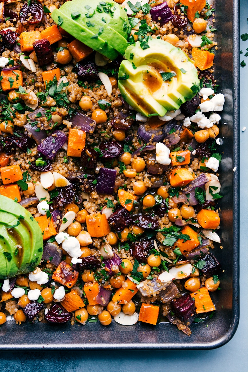 Try Sheet Pan Quinoa Pilaf -- we roast veggies and quinoa all on two sheet pans and then toss it all together with an irresistible balsamic dressing! Recipe via ChelseasMessyApron #dinner #quick #easy #simple #best #onepan #avocado #healthy #whole #whole30 #quinoa #pilaf Overhead view of the sheet pan Quinoa Pilaf on a sheet pan
