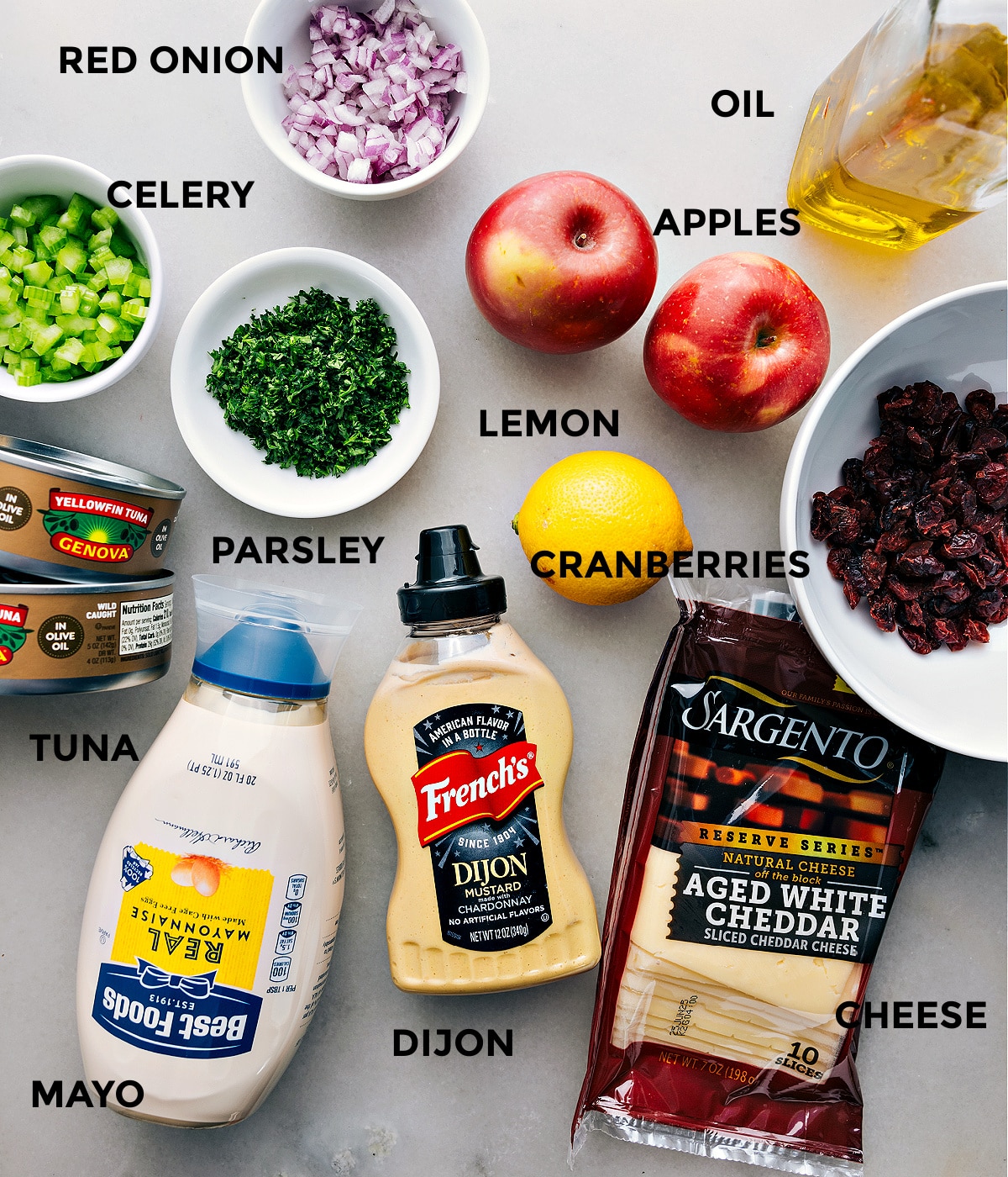 Ingredients In This Easy Tuna Salad Recipe All the ingredients in this recipe are prepped and ready for easy assemblyโapples, cranberries, lemon, oil, onion, celery, parsley, cheddar, Dijon, mayo, and meat.