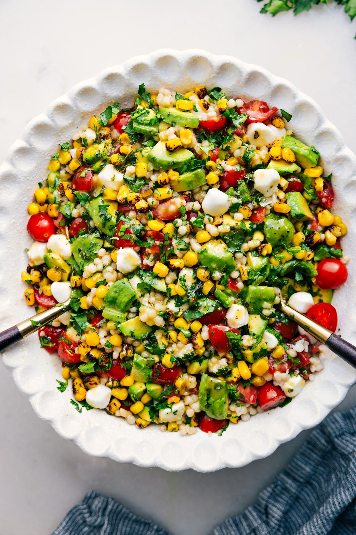 The Best Summer Couscous Salad Summer Couscous Salad in a bowl with fresh ingredients and a drizzle of dressing.