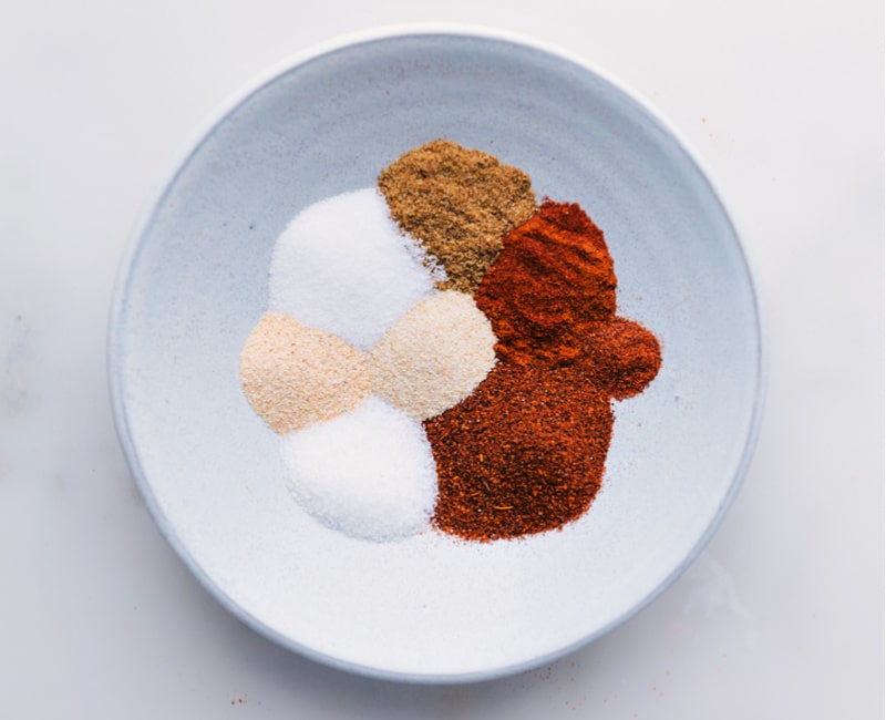 Our favorite Fajita Seasoning blend is so simple to make and uses spices you probably already have in your cabinet! Skip the store-bought packets; you'll never want to use them again after seeing how easy and delicious making your own seasoning blends is. Recipe via ChelseasMessyApron #homemade #mexican #fajita #seasoning #mix Overhead image of all the spices added to a bowl