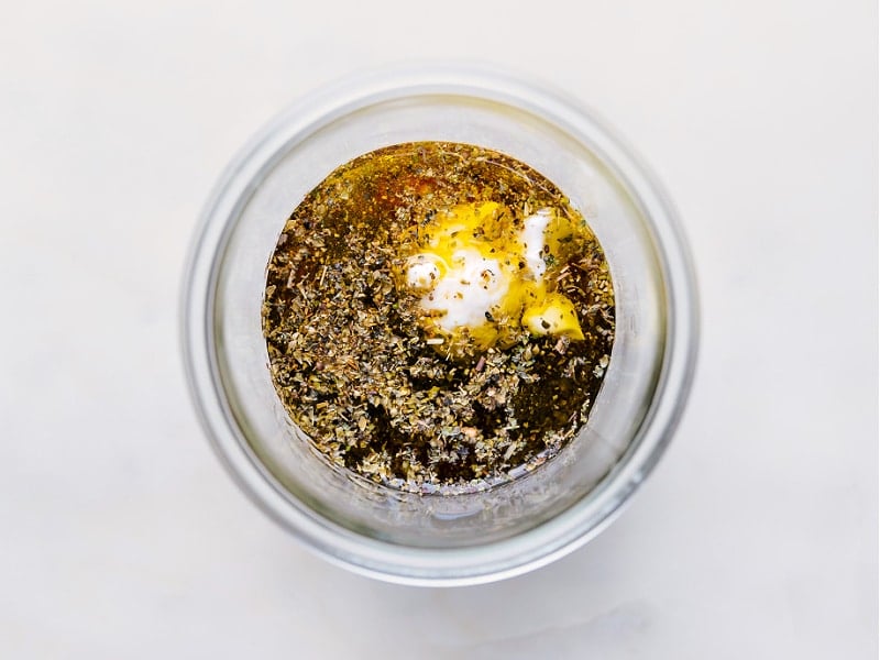 Italian Dressing made from scratch is a complete game changer -- it's so much better than store-bought! Recipe via ChelseasMessyApron #quick #easy #simple #healthy #best #vinagrette #italian #dressing Process shots of Italian salad dressing-- images of all the ingredients being added to a jar