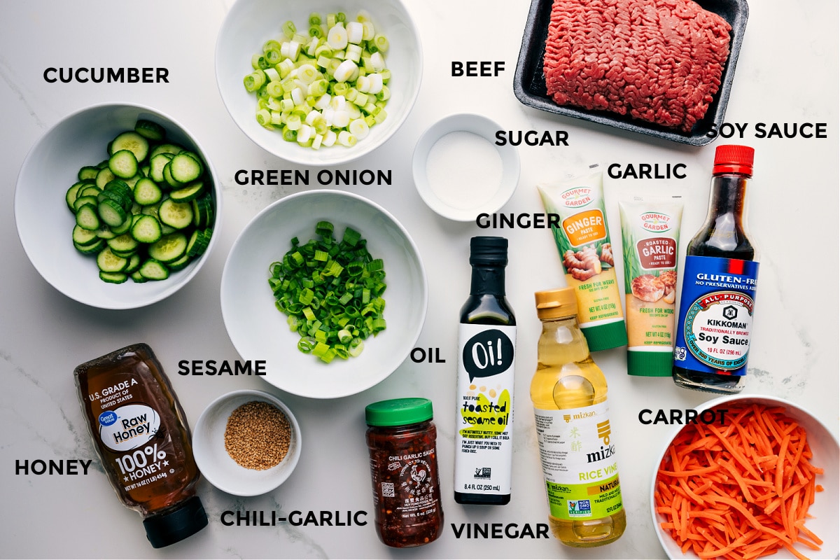 Ingredients In Korean Ground Beef All the ingredients for this recipe are prepped and ready for easy assembly, including the meat, green onions, soy sauce, garlic, cucumber, ginger, carrot, vinegar, oil, chili garlic sauce, sesame oil, and honey.
