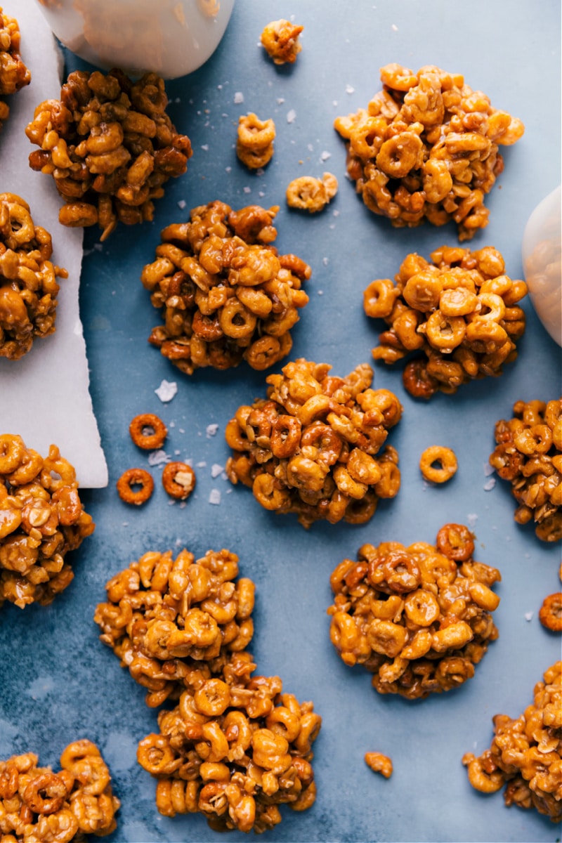 These no-bake Peanut Butter Cereal Bites are quick and easy to make! They've only got five ingredients and are naturally sweetened -- the perfect addition to your lunch or a great after-school snack! Recipe via ChelseasMessyApron #dessert #snack #quick #easy #simple #best #kidfriendly #peanutbutter #cerealbites Peanut Butter Cereal Bites spread out on a board.