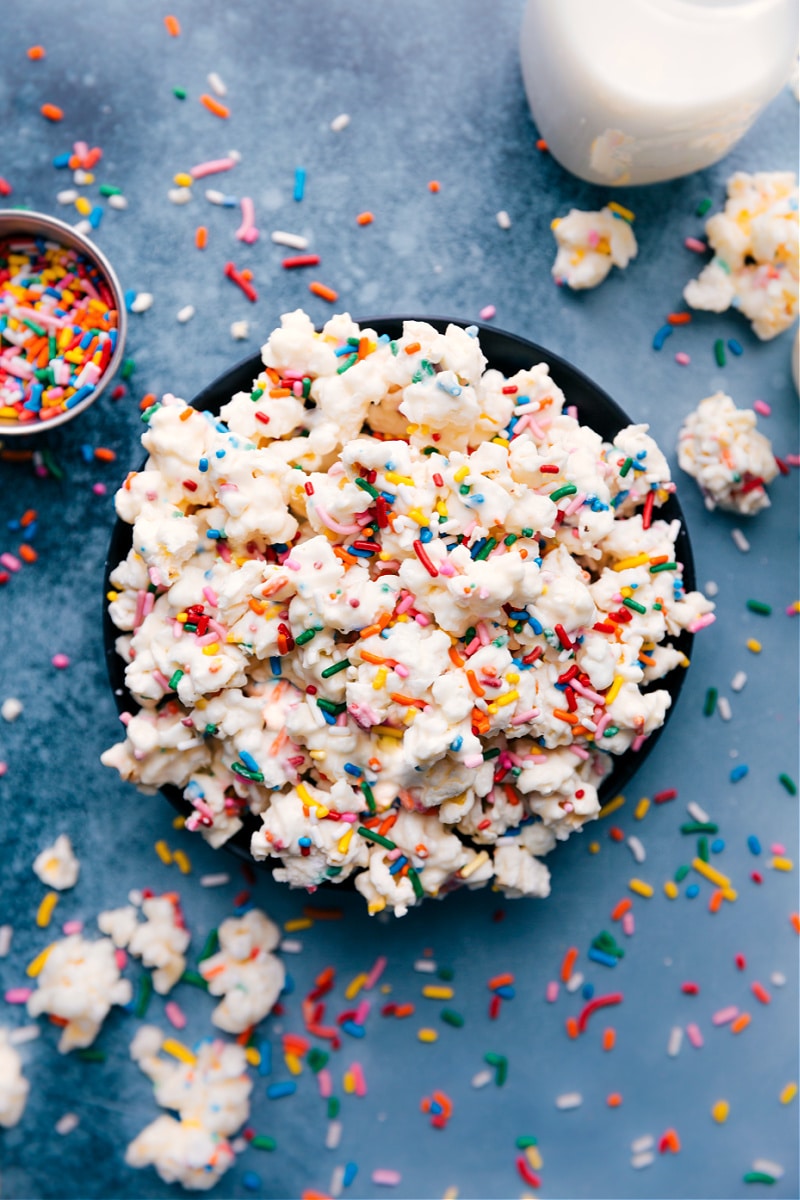 Thisย Cake Batter Popcorn is sweet, crunchy, and loaded with sprinkles! We toss the popcorn in melted chocolate and an actual cake mix for a true cake batter flavor experience! Recipe via ChelseasMessyApron.com #Popcorn #gourmet #quick# easy# cakebatter #cakebatterpopcorn #snack #movienight #treat Cake Batter Popcorn