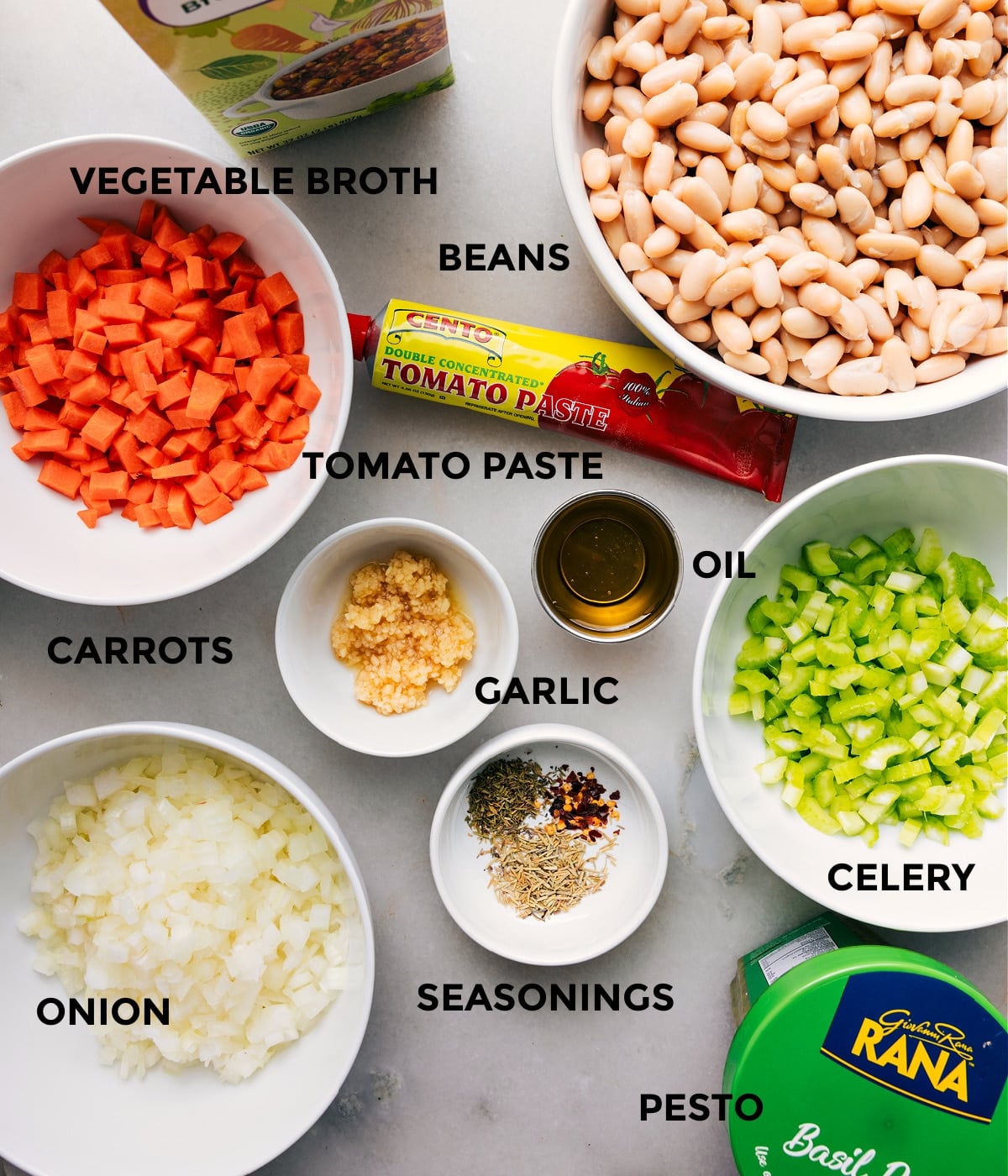 Ingredients In White Bean Soup Recipe All the ingredients for this recipe are prepped and ready for easy assembly, including broth, beans, paste, oil, garlic, veggies, seasonings, and pesto.