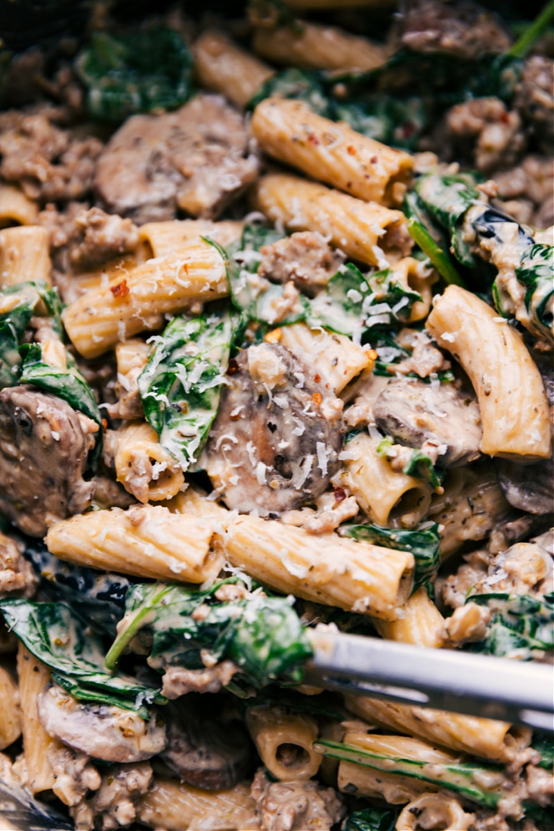 Creamy Sausage And Mushroom Rigatoni is a restaurant-quality meal that is easy to make and is prepared with everyday ingredients. This is comfort food at its finest -- rigatoni pasta tossed in a creamy Italian-seasoned sausage and mushrooms sauce. Recipe via ChelseasMessyApron #dinner #quick #easy #simple #best #comfortfood #kidfriendly #creamy #sausage #mushroom #rigatoni Up-close overhead image of Creamy Sausage and Mushroom Rigatoni in the pot