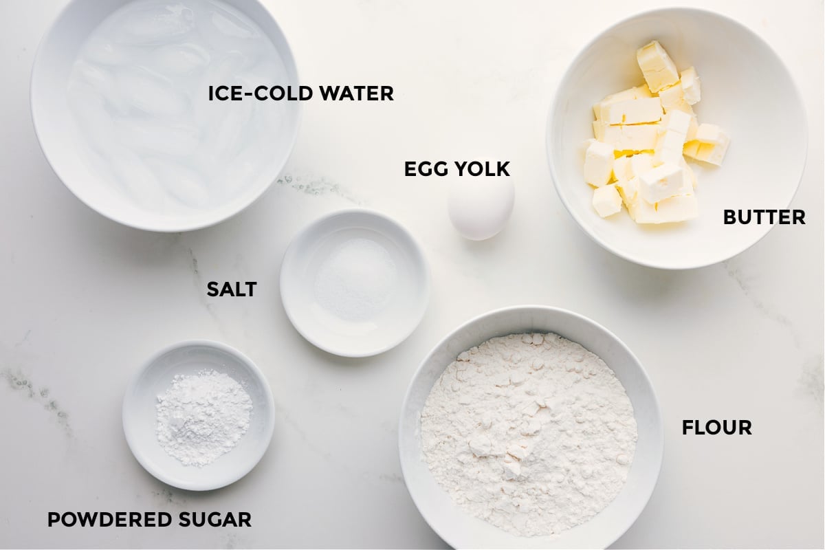 Ingredients In The Best Pie Crust Recipe All the ingredients prepped and ready: flour, butter, egg, salt, powdered sugar, and ice cold water for easy assembly.