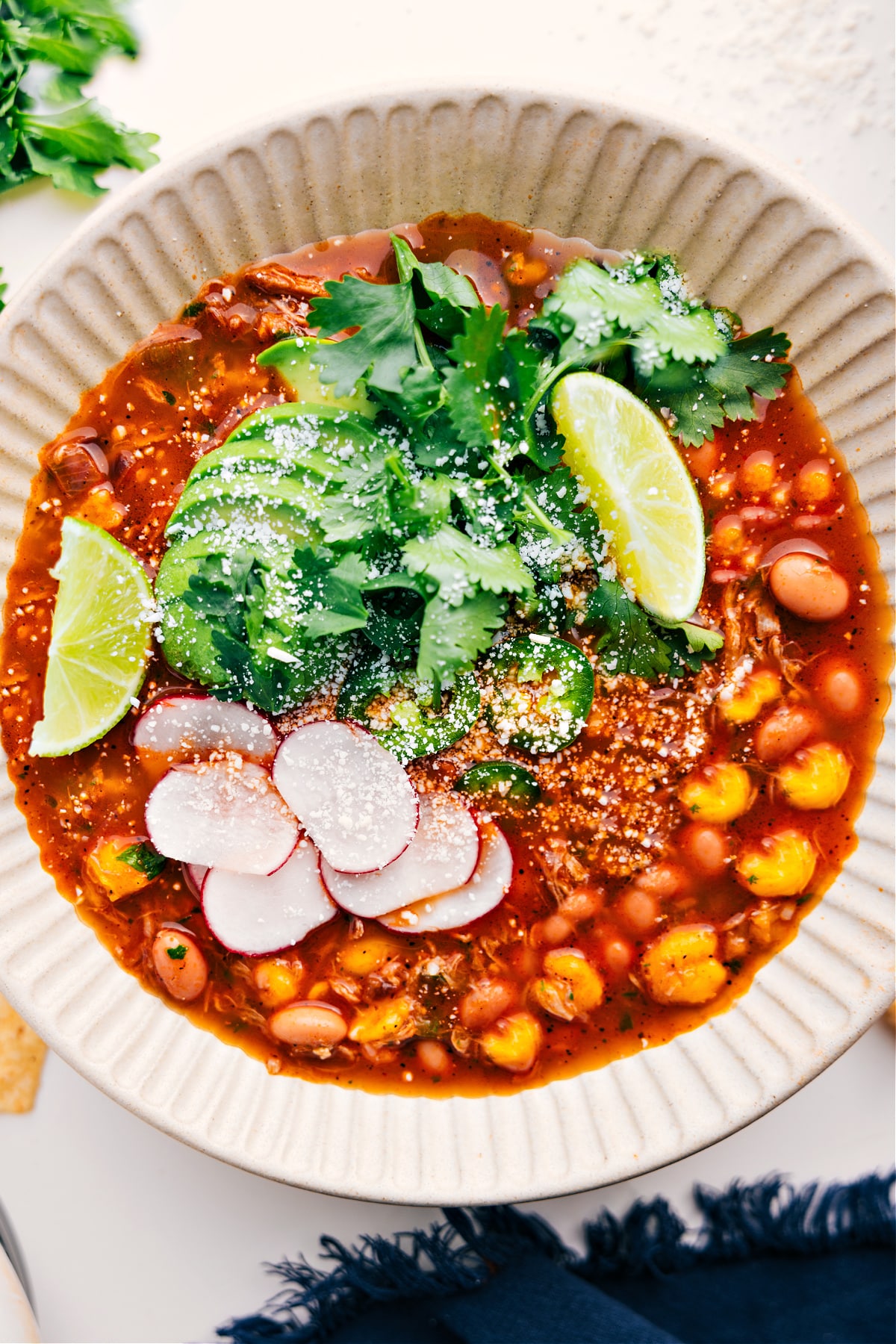 Mexican Inspired Pozole Recipe 30-minute Mexican inspired Pozole Recipe in a bowl with avocado, cilantro, and limes on the top.