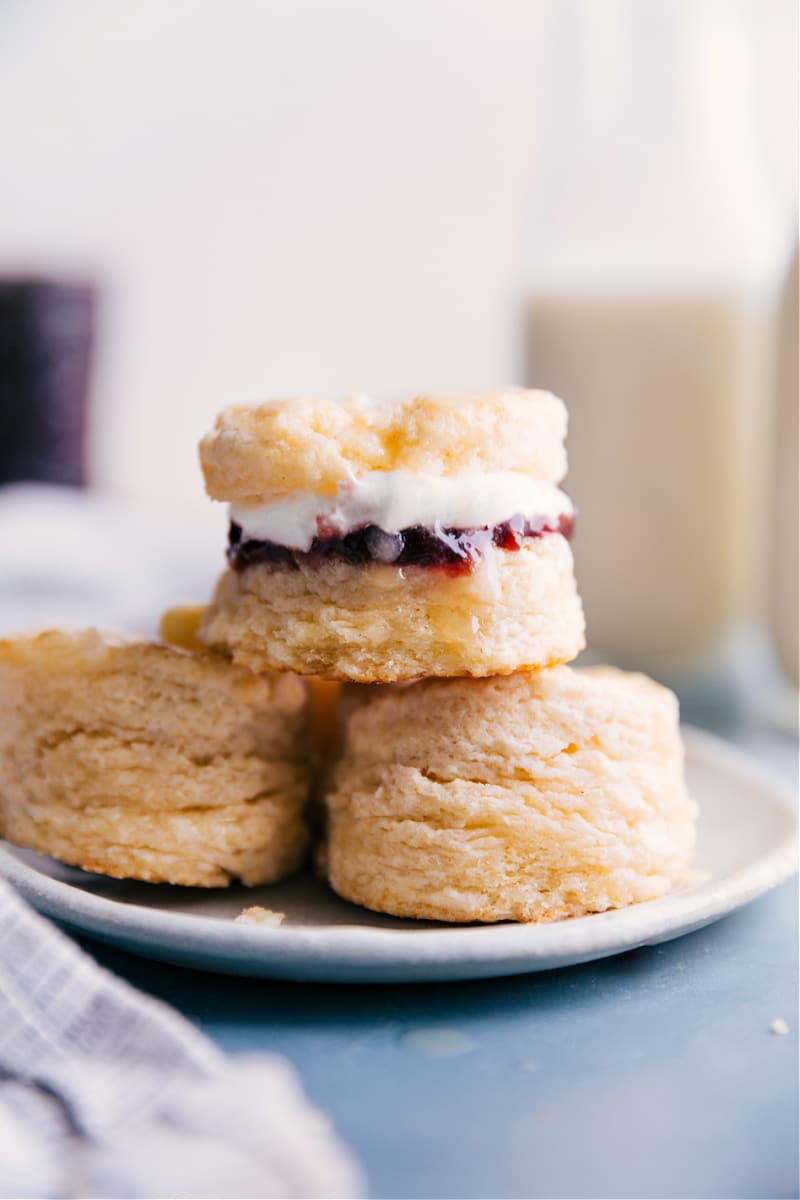 This show-stopping Biscuit Recipe is ridiculously simple to make and requires only 5 ingredients -- most of which are pantry staples! Whip up a batch of these buttery biscuits to serve alongside a hearty dinner or enjoy them with butter, jam, and whipped cream for a sweet treat! Recipe via ChelseasMessyApron.com #biscuits #carbs #easy #bread #delicious A plate of biscuits