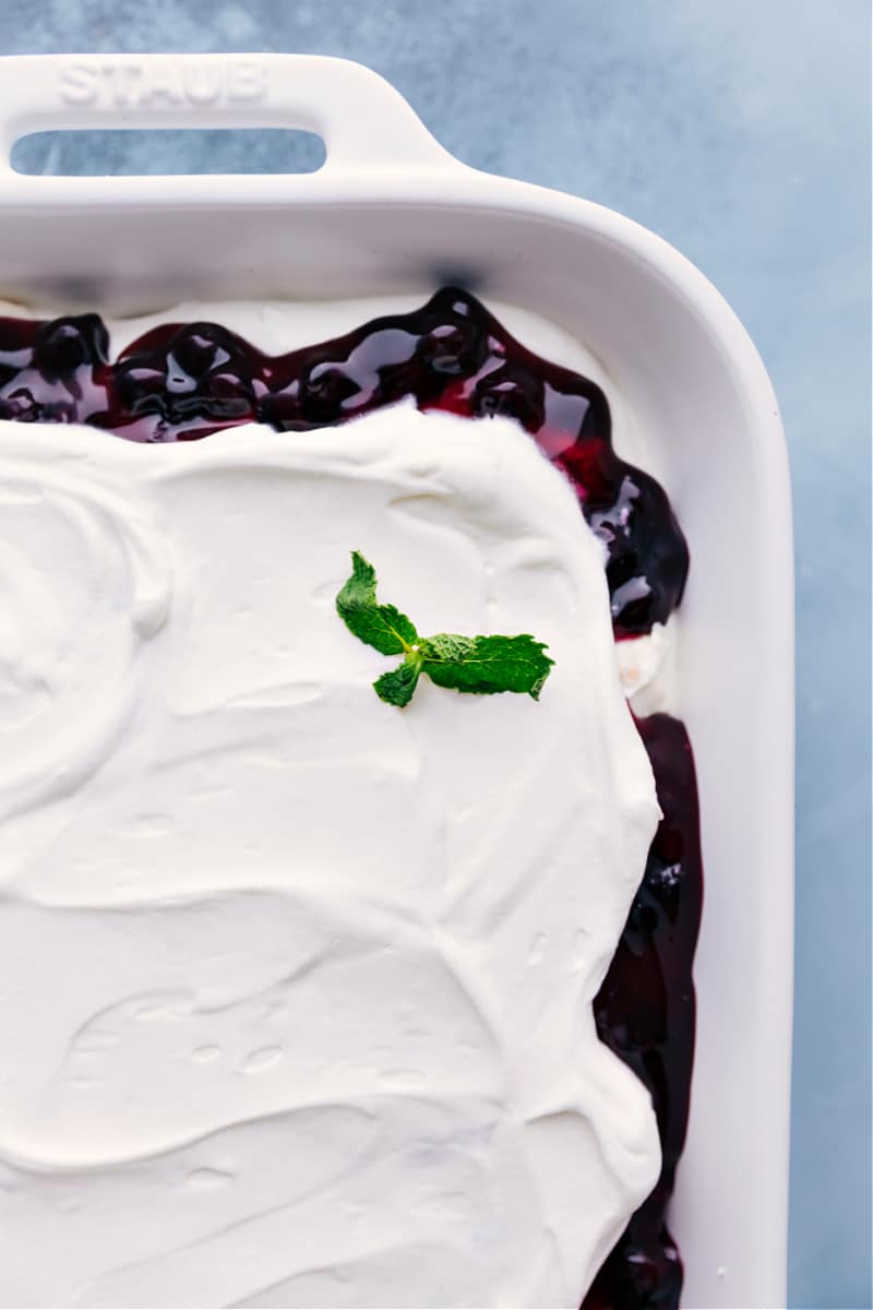 Blueberries and Cream Cake Trifle is a layered dessert with creamy angel food cake cubes, blueberry fruit filling, and whipped cream. Recipe via ChelseasMessyApron.com #blueberry #cheesecake #angelfood #dessert #holidays #creamcheese Closeup view of Blueberries and Cream Cake Trifle