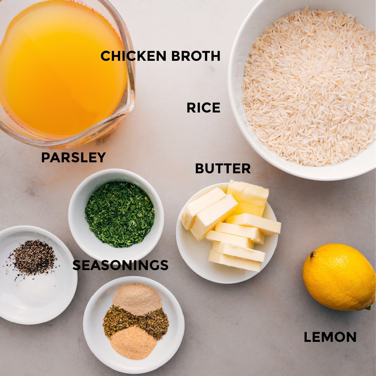 Ingredients In Herb Rice Recipe All the ingredients for this recipe are prepped for easy assembly: chicken broth, seasonings, butter, rice, lemon, and fresh parsley.