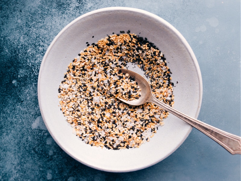 Everything Bagel Seasoning is one of our all-time favorite seasoning blends -- flavorsome, crackly-crunchy, and garlicky! The applications for this seasoning are nearly endless -- obviously you can add it atop homemade bagels, but it also goes great on eggs, avocado toast, or sprinkled into your favorite chicken breading! Recipe via ChelseasMessyApron #garlic #poppyseeds #sesameseeds #everythingbagel #seasoning Overhead image of Everything Bagel Seasoning ready to be served