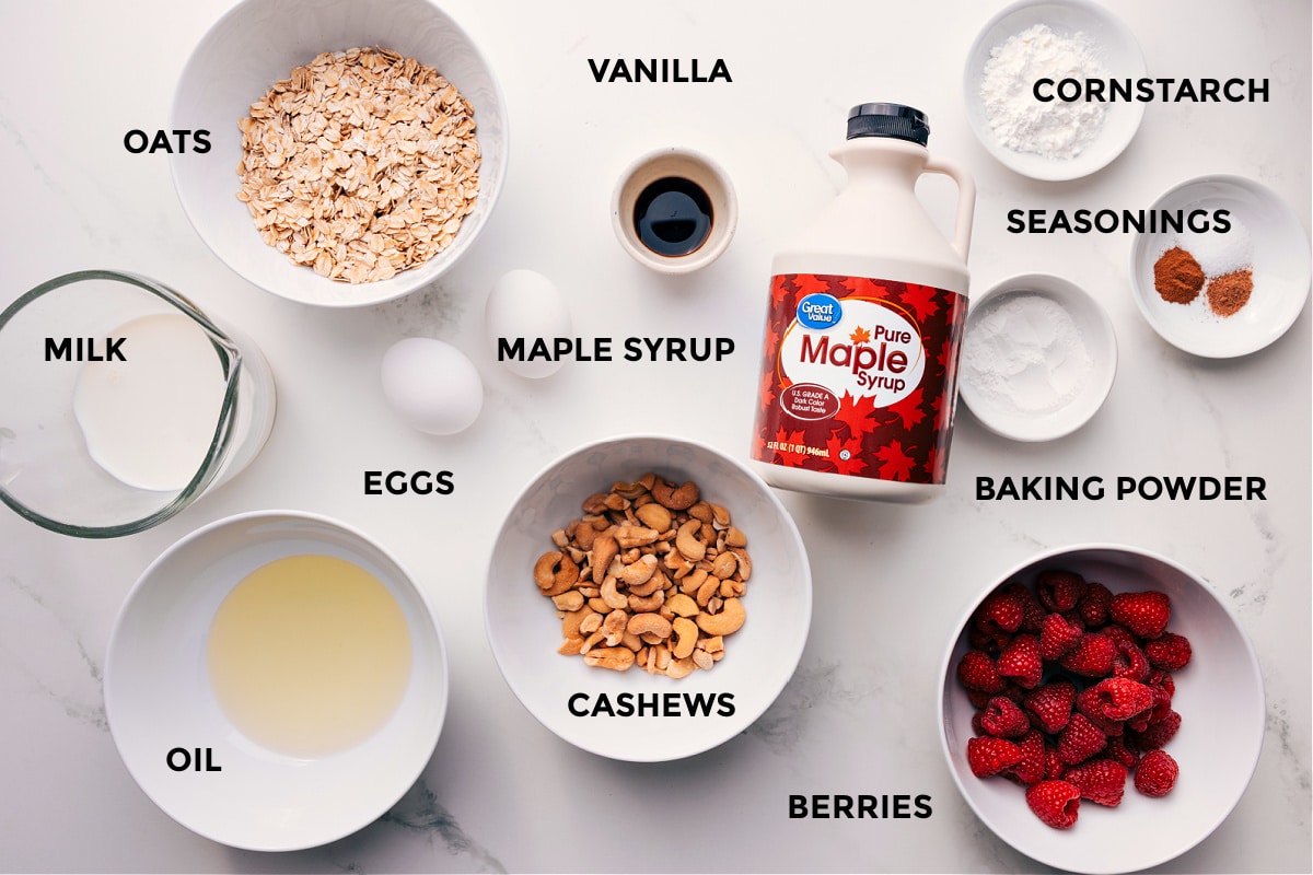 Ingredients In Healthy Waffle Recipe Ingredients prepped for easy assembly, including milk, oats, oil, eggs, cashews, vanilla, maple syrup, berries, baking powder, seasonings, and cornstarch.