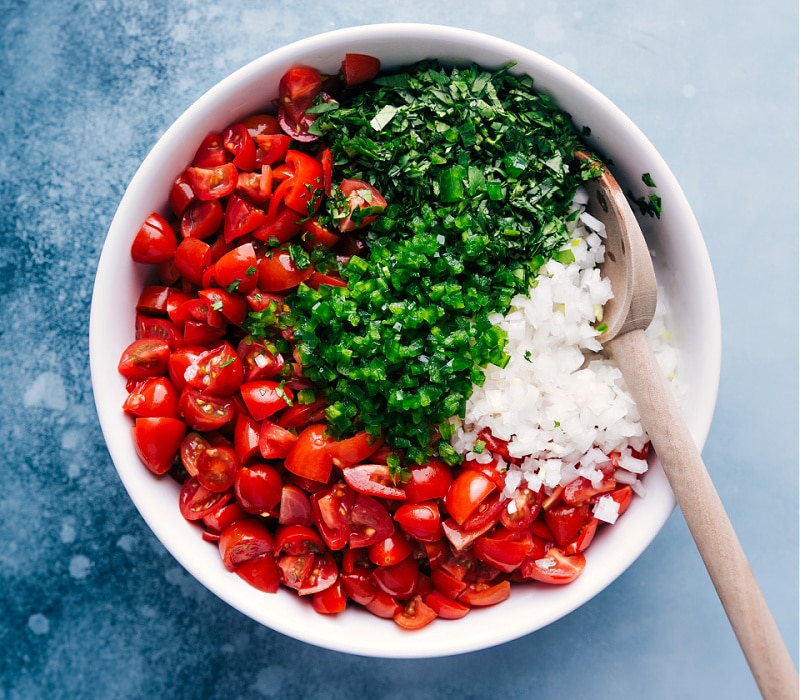 This fresh and tasty classic Pico de Gallo is made by combining diced tomatoes, onions, and peppers, with cilantro, lime juice, and salt.ย Recipe via ChelseasMessyApron #sidedish #best #quick #easy #dip #gameday #salsa #pico #degallo #healthy #cleaneating #wholefoods #picodegallo Process shots-- images of all the ingredients being added to a bowl