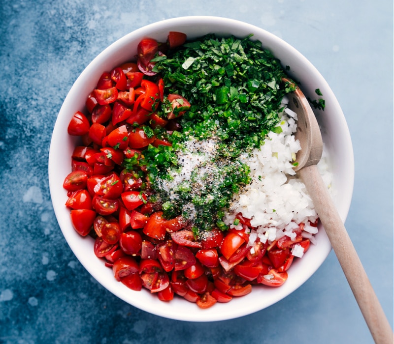 This fresh and tasty classic Pico de Gallo (also known as Salsa Fresca) is made by combining diced tomatoes, onions, and peppers, with cilantro, lime juice, and salt.ย Recipe via ChelseasMessyApron #sidedish #best #quick #easy #dip #gameday #salsa #pico #degallo #healthy #cleaneating #wholefoods #picodegallo Process shot of the Pico de Gallo-- image of the salt and pepper being added